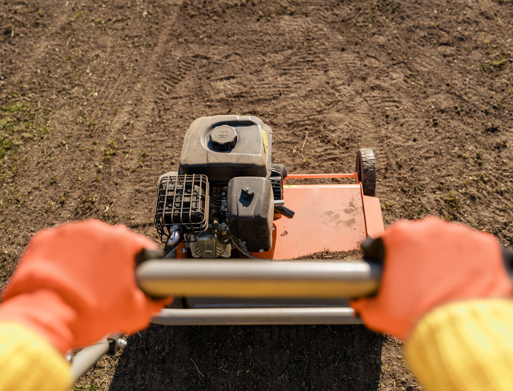 Closeup of person pushing aerator machine in the dirt - equipment rentals in Salida, Poncha Springs, Buena Vista Colorado | Iron Mountain Tool & Equipment Rental